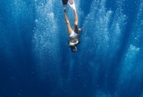 Adrenalin-Pumping Activities - Unrecognizable lady swimming underwater after jumping in ocean