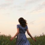 Nature Escape - Woman in Blue Striped Dress Running on the Green Grass Field