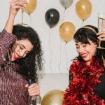 Make Friends - Cheerful friends with glasses of tasty champagne smiling and congratulating each other among balloons