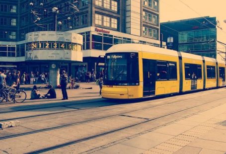 Work And Travel - Selective Color Photography of Yellow Train Near Concrete Buildings