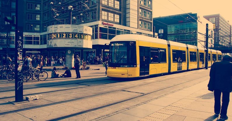 Work And Travel - Selective Color Photography of Yellow Train Near Concrete Buildings